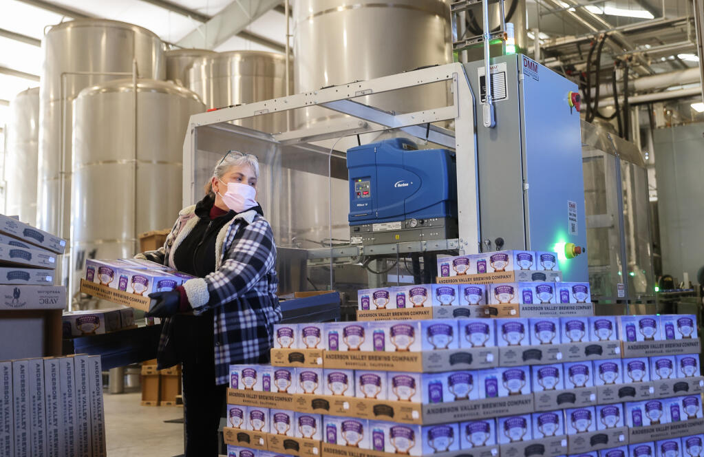 Ana Pena moves packed cans of Anderson Valley Brewing Company's Hop Ottin' IPA off the canning line at their facility in Boonville on Thursday, Feb. 24, 2022. (Christopher Chung/ The Press Democrat)
