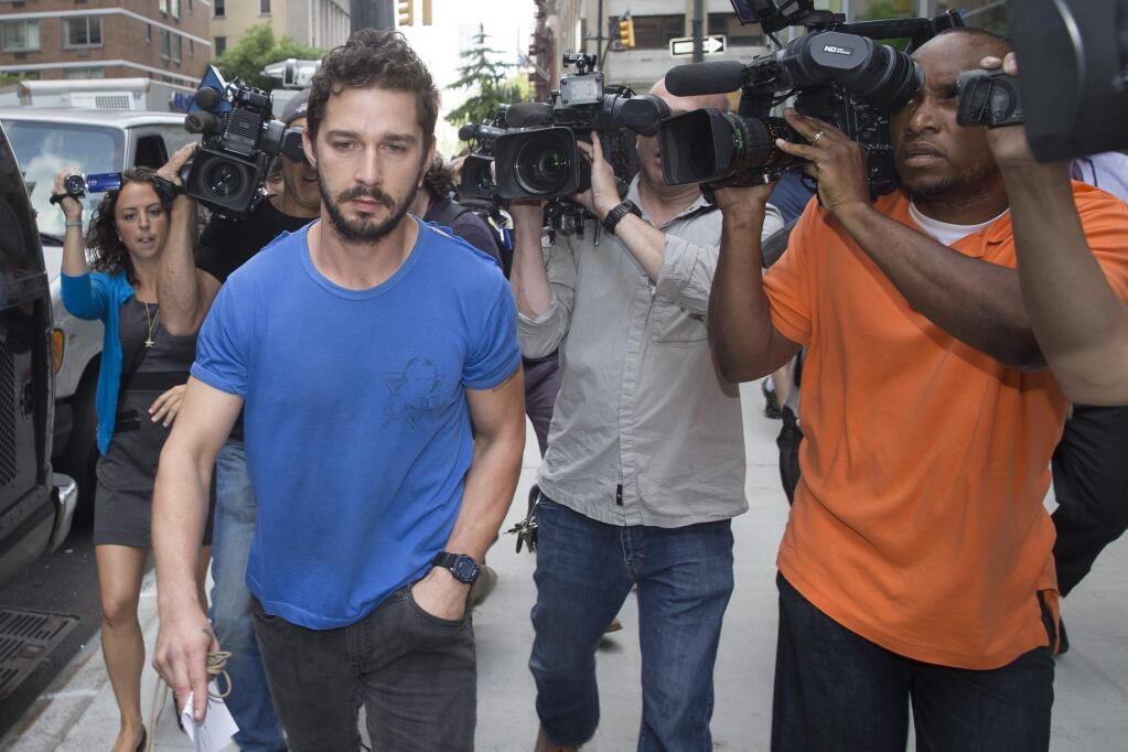 FILE - In this June 27, 2014 file photo, actor Shia LaBeouf walks through the media after leaving Midtown Community Court in New York following his arrest the previous day for yelling obscenities at the Broadway show 'Cabaret.' LaBeouf on Wednesday, Sept. 10, 2014 pleaded guilty to disorderly conduct stemming from the incident. (AP Photo/John Minchillo, File)