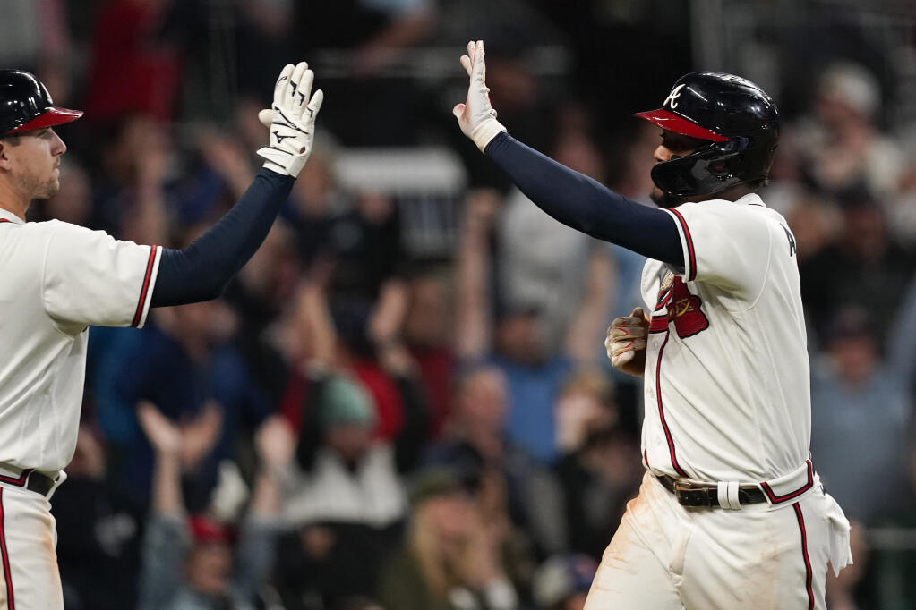The Braves’ Ronald Acuna Jr., right, scores after Matt Olson hit an RBI single during the sixth inning in Game 2 of the National League Division Series against the Philadelphia Phillies, Wednesday, Oct. 12, 2022, in Atlanta. (Brynn Anderson / ASSOCIATED PRESS)