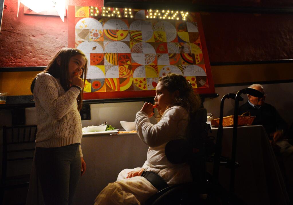 Jazzlin Mejia, 8, right, nibbling on carrots with her best friend Lila Seufert, 8, during Dear Jazzy, a benefit held at the Mystic Theater in Petaluma, California for Jazzlin Mejia who was paralyzed in 2013 when a drunk driver crashed into the car which she and her father were riding. November 20, 2016.(Photo: Erik Castro/for The Press Democrat)