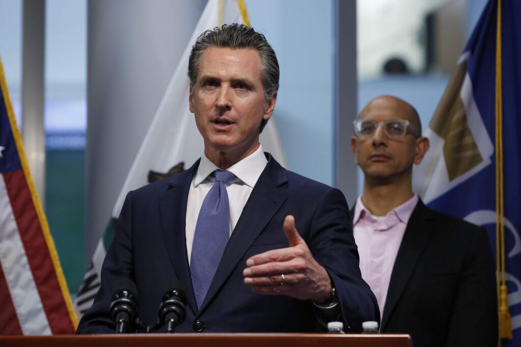 California Gov. Gavin Newsom updates the state's response to the coronavirus, at the Governor's Office of Emergency Services in Rancho Cordova Calif., Tuesday, March 17, 2020. At right is California Health and Human Services Agency Director Dr. Mark Ghaly. (AP Photo/Rich Pedroncelli, Pool)