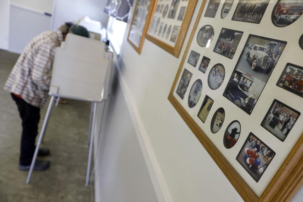 Photos of past community events hang on the wall in McCaughey Hall where Patrick Prather votes on Tuesday, June 5, 2018 in Bodega, California. (BETH SCHLANKER/ PD)