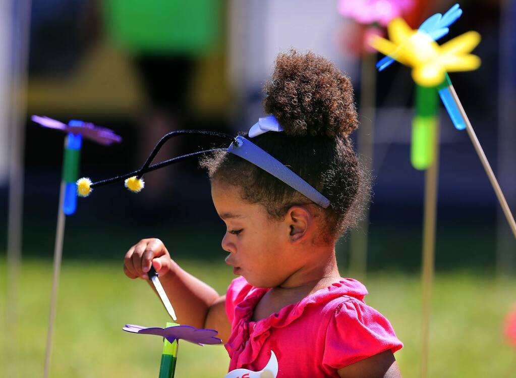 Esme Iddeen, 4, of Petaluma pretends she's a bee polinating flowers in a game sponsored by the Sonoma County Beekeepers Association at the Farmer Olympics at the Petaluma Fairgrounds on Saturday. (John Burgess/The Press Democrat)