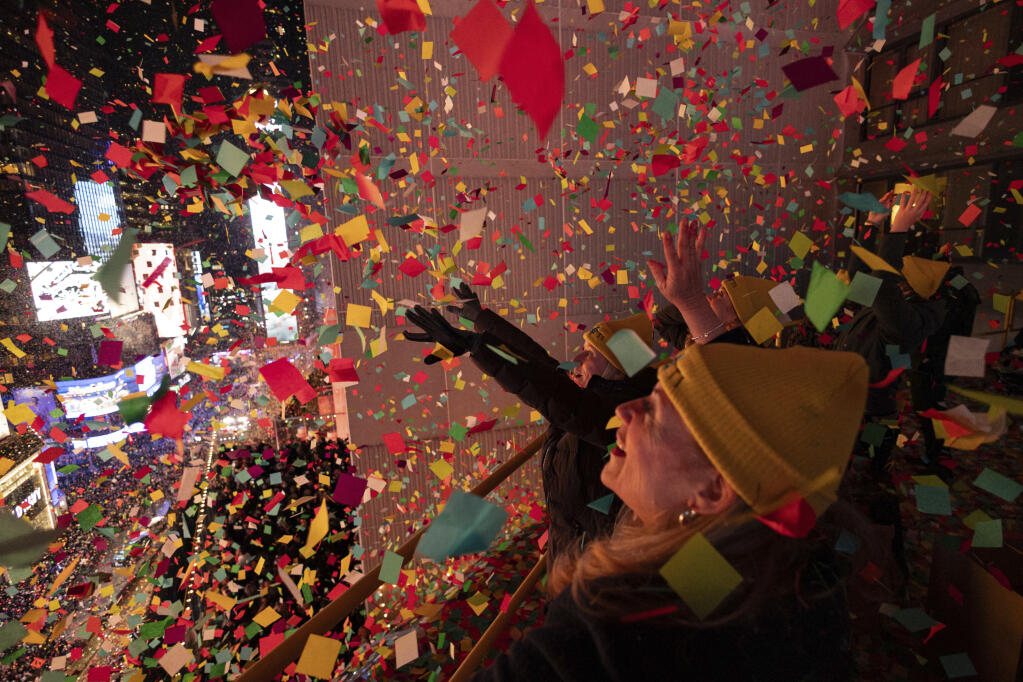 Times Square Alliance volunteers throw confetti as the clock strikes midnight as seen from the New York Marriott Marquis during the New Year's Eve celebration in Times Square, Monday, Jan. 1, 2024, in New York. (AP Photo/Yuki Iwamura)