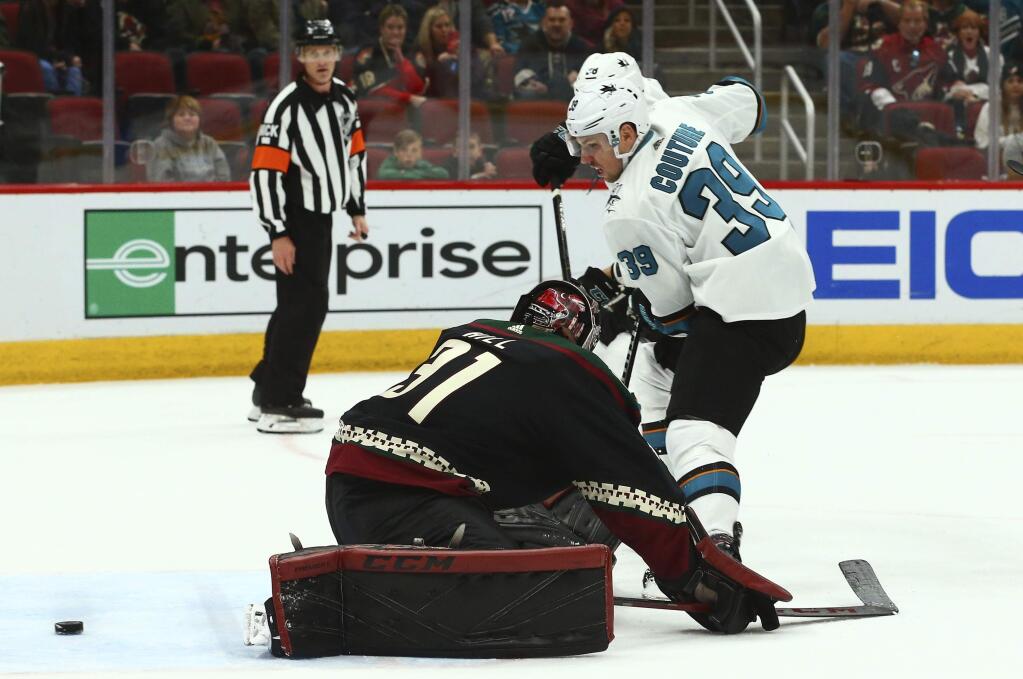 San Jose Sharks center Logan Couture scores a goal against Arizona Coyotes goaltender Adin Hill during the first period, Saturday, Dec. 8, 2018, in Phoenix. (AP Photo/Ross D. Franklin)