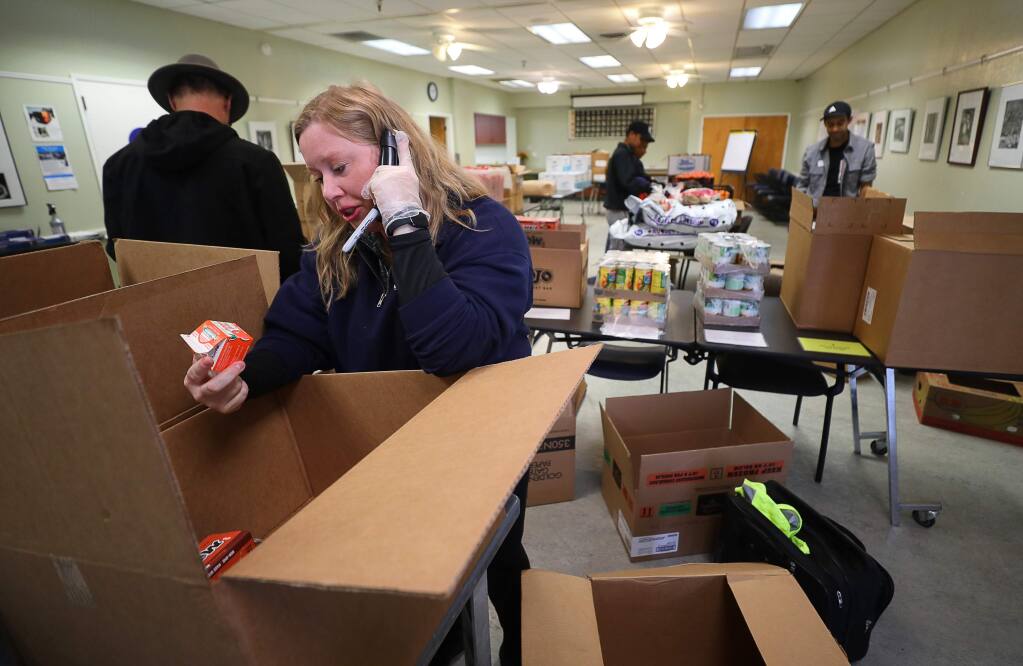 Anna Grant, active adult and senior services supervisor with the City of Healdsburg, talks with a senior citizen on the phone to determine what food they want delivered to their home, at the Healdsburg Senior Center on Wednesday, March 18, 2020. The Redwood Empire Food Bank provided the food for delivery to seniors.(Christopher Chung/ The Press Democrat)