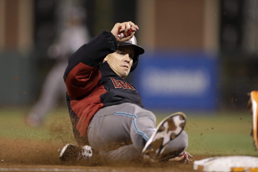 Arizona Diamondbacks' Zack Greinke slides as he is forced out at third on a bunt by Michael Bourn, who was safe at first during the fifth inning of a baseball game Tuesday, Aug. 30, 2016, in San Francisco. (AP Photo/Marcio Jose Sanchez)