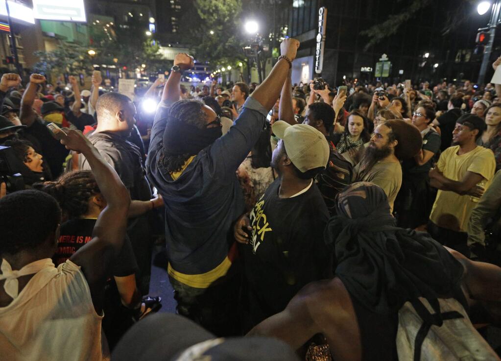 Protesters shout as they march downtown on the third night of protests in Charlotte, N.C. Thursday, Sept. 22, 2016, following Tuesday's fatal police shooting of Keith Lamont Scott in Charlotte, N.C. (AP Photo/Chuck Burton)