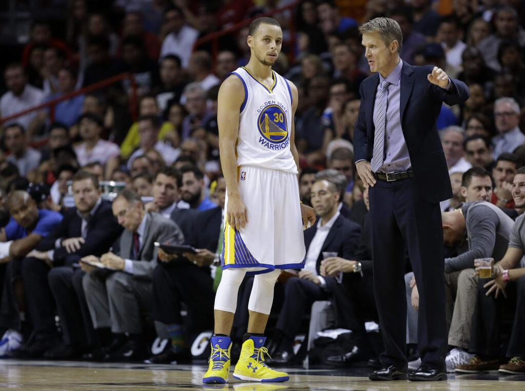 Golden State Warriors guard Stephen Curry (30) talks with head coach Steve Kerr, right, in the second half of an NBA basketball gam against the Miami Heate, Tuesday, Nov. 25, 2014, in Miami. Golden State defeated the Heat 114-97. (AP Photo/Lynne Sladky)