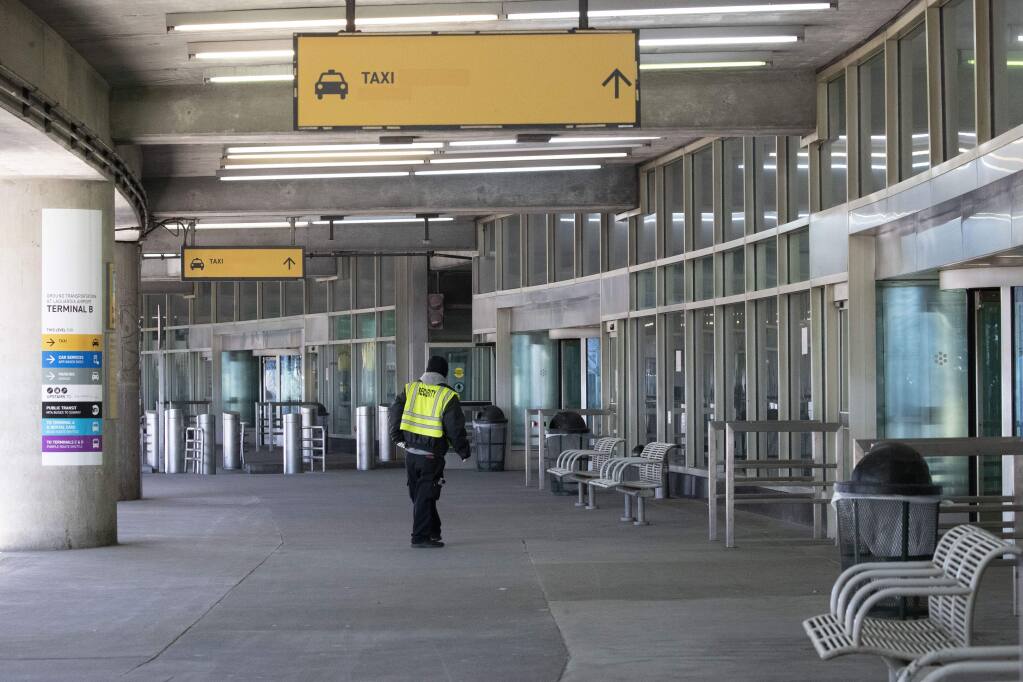 A security guard stands alone Saturday at one of the arriving passenger pick-up areas at New York's LaGuardia Airport. (MARY ALTAFFER / Associated Press)