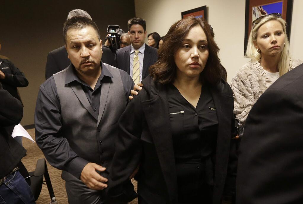Rodrigo Lopez and Sujay Cruz, the parents of Andy Lopez, leave after speaking at a news conference in San Francisco on Nov. 4, 2013. On Tuesday, the Sonoma County Board of Supervisors approved a $3 million settlement of their lawsuit. (JEFF CHIU / Associated Press)