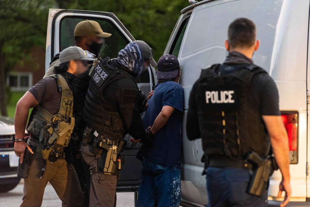 Immigration and Customs Enforcement officers detain a man on a recent Enforcement and Removal Operation; location and identification unavailable.