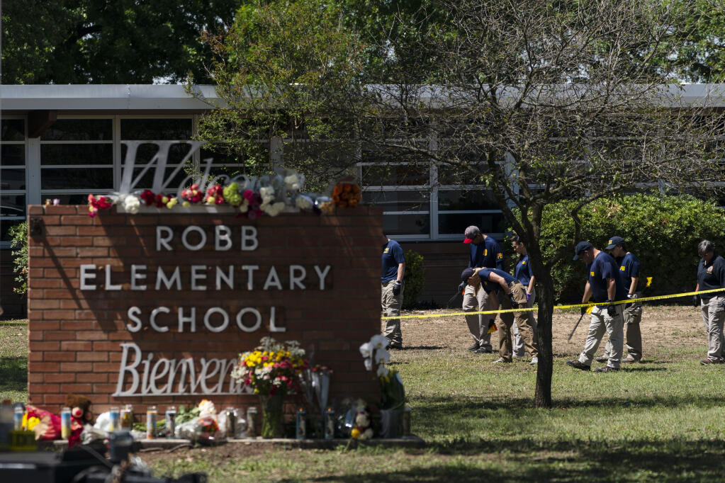 FILE - Investigators search for evidences outside Robb Elementary School in Uvalde, Texas, May 25, 2022. The children who survived the attack, which killed 19 schoolchildren and two teachers, described a festive, end-of-the-school-year day that quickly turned to terror. (AP Photo/Jae C. Hong, File)