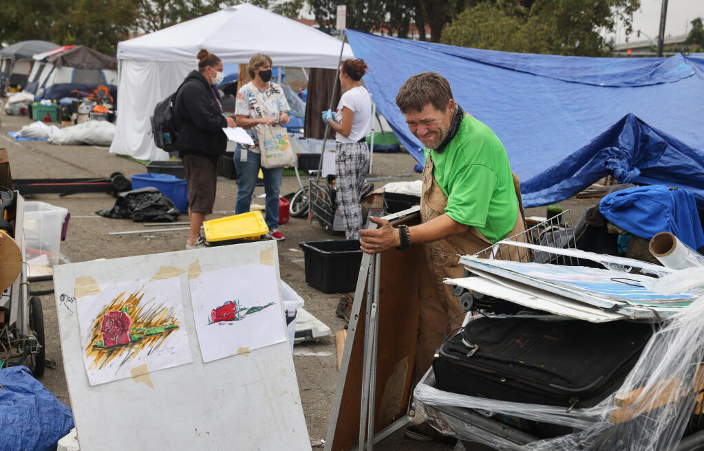 Richard Wayne Seward packs up his belongings from the homeless encampment at the Roberts Lake Park and Ride lot in Rohnert Park on Friday, September 10, 2021.  (Christopher Chung/ The Press Democrat)