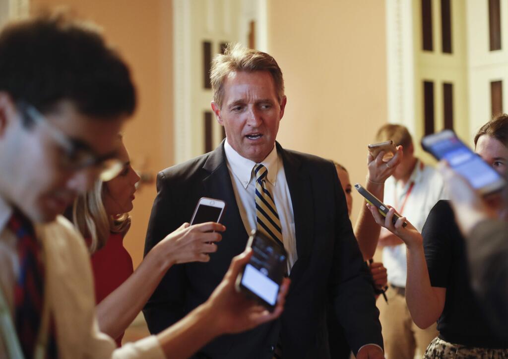 FILE - In this July 13, 2017, file photo, Sen. Jeff Flake, R-Ariz. speaks to members of the media as he walks to a meeting on Capitol Hill in Washington. There wasn't a dramatic public break, or a precise moment when it happened. But little by little, Senate Republicans have been turning their backs on President Donald Trump. They've defied his Twitter demands, defeated his top agenda item and passed veto-proof sanctions on Russia over administration objections. Flake took aim at Trump and his own party in a new book, writing that “Unnerving silence in the face of an erratic executive branch is an abdication” and “the strange specter of an American president's seeming affection for strongmen and authoritarians created such a cognitive dissonance among my generation of conservatives _ who had come of age under existential threat from the Soviet Union _ that it was almost impossible to believe.” (AP Photo/Pablo Martinez Monsivais, File)