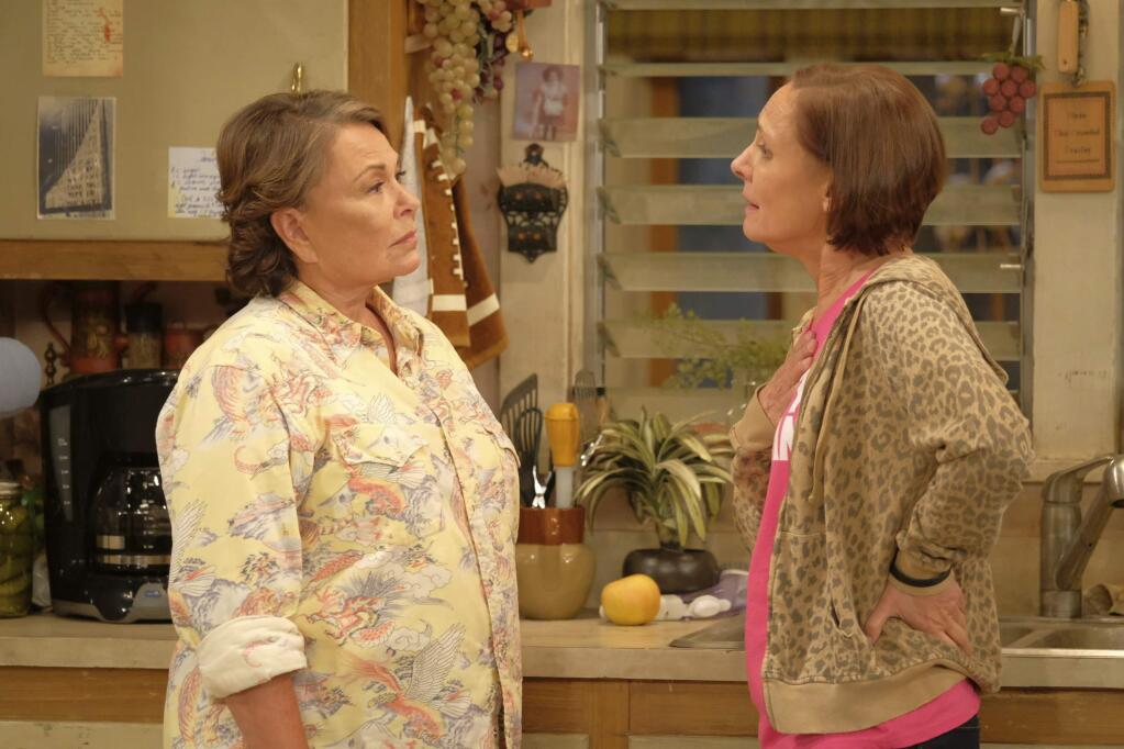 In this image released by ABC, Roseanne Barr, left, and Laurie Metcalf appear in a scene from the reboot of the popular comedy series 'Roseanne.' ABC, which canceled its 'Roseanne' revival over its star's racist tweet, said Thursday, June 21, 2018, it will air a Conner family sitcom minus Roseanne Barr this fall. (Adam Rose/ABC via AP)