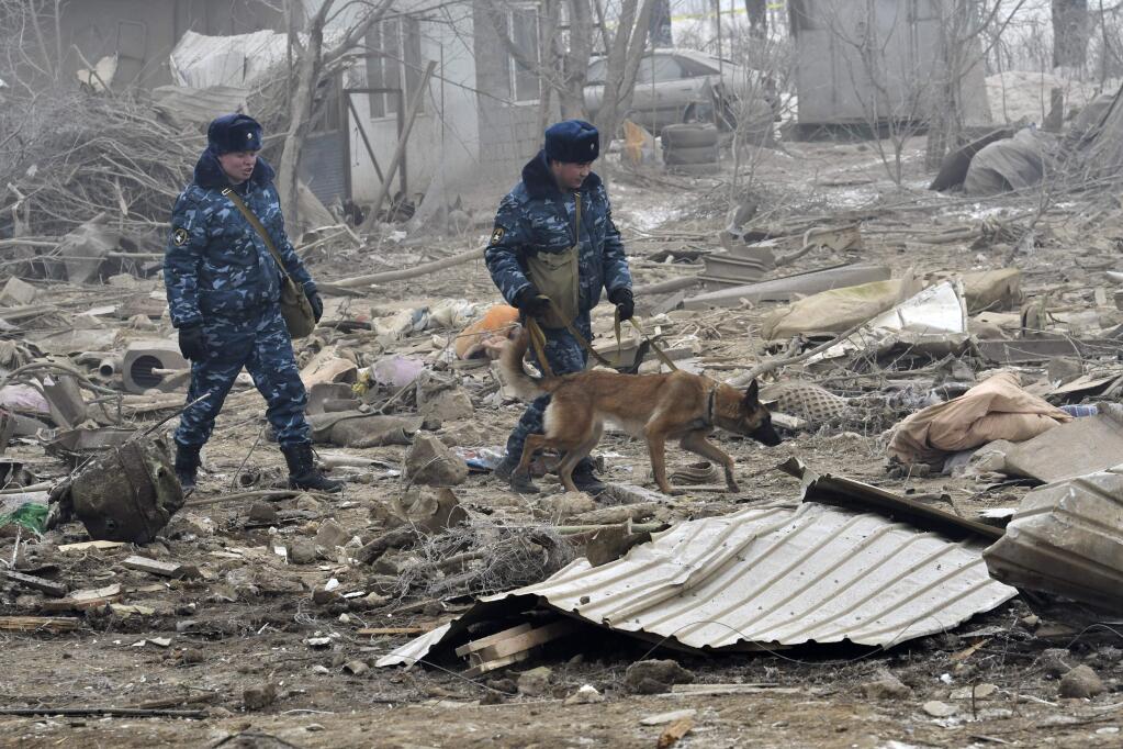 Kyrgyz soldiers with a sniffer dog search among remains of a crashed Turkish Boeing 747 cargo plane at a residential area outside Bishkek, Kyrgyzstan Monday, Jan. 16, 2017. The cargo plane crashed Monday morning, killing people in the residential area adjacent to the Manas airport as well as those on the plane. (AP Photo/Vladimir Voronin)