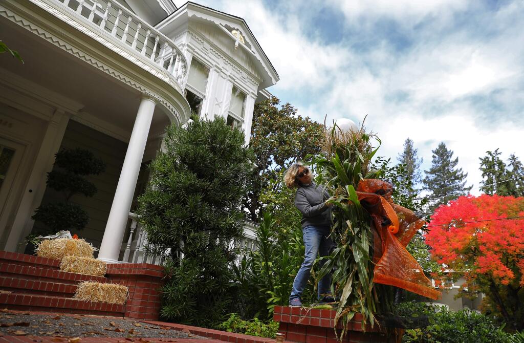Maria Philbin helps to decorate Cathy Grace Hays' McDonald Avenue home for Halloween, in Santa Rosa on Monday, October 30, 2017. (Christopher Chung/ The Press Democrat)