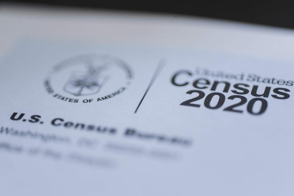FILE - This March 18, 2020 file photo taken in Idaho shows a form for the U.S. Census 2020. Filling out this year's census form won't get you a check from the federal government as claims circulating on social media suggest. The posts state that if you respond to the census, you will receive a $1,200 stimulus check from the federal government that's intended to help Americans during the COVID-19 pandemic. Congress is considering mailing checks directly to households, but hasn't approved funding for the stimulus funding package yet. (John Roark/The Idaho Post-Register via AP, File)