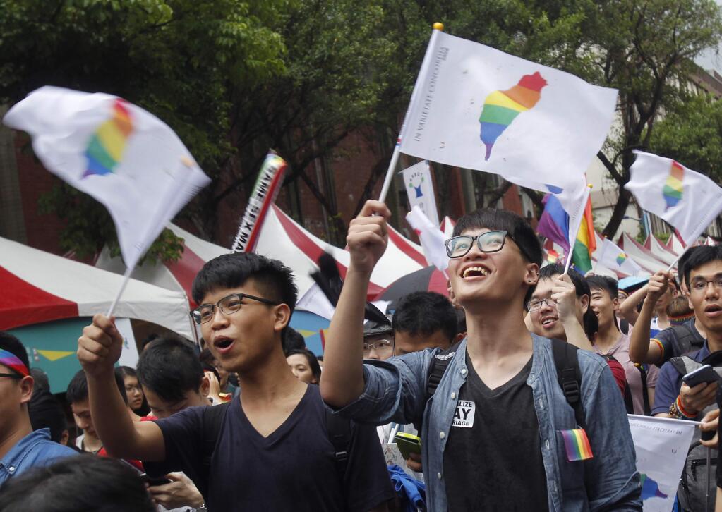 Same-sex marriage supporters wave rainbow Taiwan flags after the Constitutional Court ruled in favor of same-sex marriage outside the Legislative Yuan in Taipei, Taiwan, Wednesday, May 24, 2017. Taiwan's Constitutional Court ruled in favor of same-sex marriage on Wednesday, making the island the first place in Asia to recognize gay unions. (AP Photo/Chiang Ying-ying)