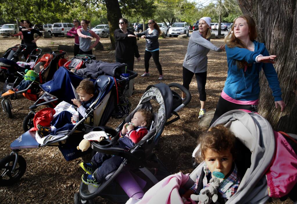 -Babies are actively engaged while moms exercise during a Fit4Mom class at Howarth Park in Santa Rosa.