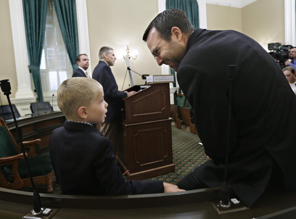 Leukemia survivor Rhett Krawitt, 7, talks with Sen. Ben Allen, D-Santa Monica, who is the co-author of measure requiring nearly all California school children to be vaccinated, at a news conference at the Capitol in Sacramento, Calif., Wednesday, June 24, 2015. Rhett, who was accompanied by his father, Carl Krawitt, background center, was unable to be vaccinated while receiving treatment for his Leukemia. The state Assembly is expected to vote on the bill, Thursday. (AP Photo/Rich Pedroncelli)