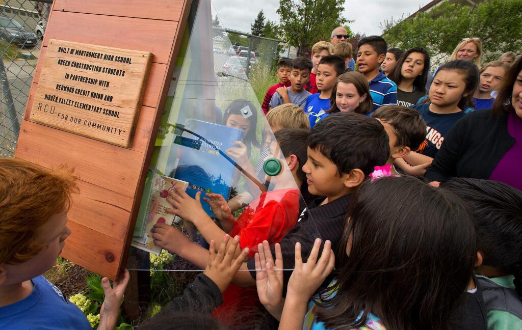 Hidden Valley Elementary students explore the selection of books inside a 'little free library' built by Montgomery High School woodworking students and sponsored by the Redwood Credit Union. (photo by John Burgess/The Press Democrat)