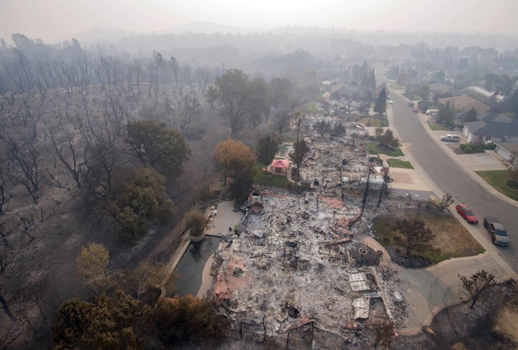 File - In this Aug. 10, 2018 file photo, homes destroyed by a wildfire are seen from an aerial view in the Mary Lake Subdivision in Redding, Calif. Fire crews have made great gains against a wildfire that has been burning for more than a month in Northern California, where it destroyed nearly 1,100 homes and killed eight people. The California Department of Fire and Forestry Protection says the blaze burning in and around the city of Redding is 93 percent contained as of Wednesday, Aug. 22, 2018. (AP Photo/Michael Burke, File)