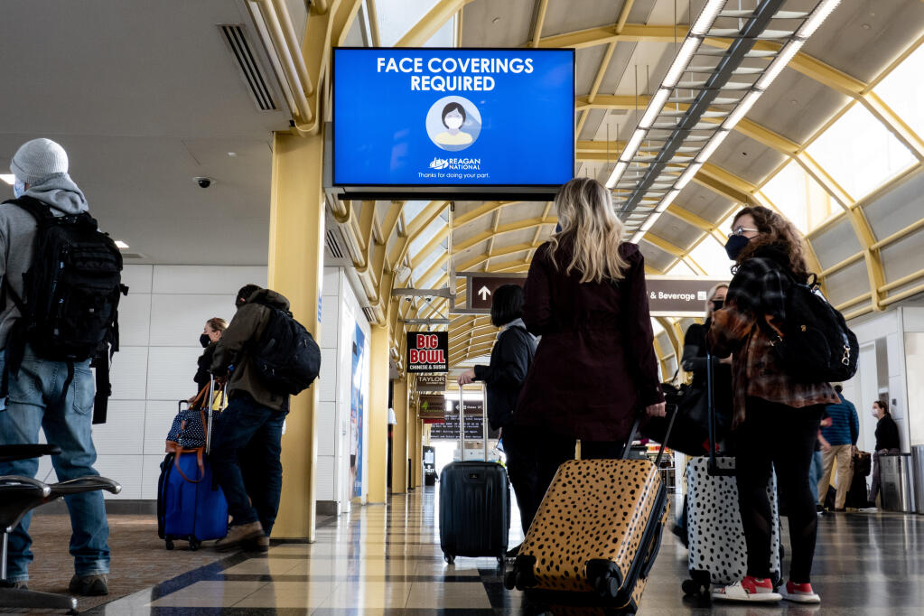 Travelers pass through Ronald Reagan National Airport in Arlington, Virginia, near Washington, on Feb. 24, 2021. Businesses and universities want fast, easy ways to see if students and customers are vaccinated, but conservative politicians have turned "vaccine passports" into a cultural flash point. (Erin Schaff/The New York Times)