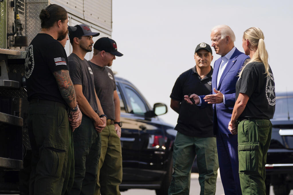 President Joe Biden greets firefighters as he tours the National Interagency Fire Center, Monday, Sept. 13, 2021, in Boise, Idaho. (AP Photo/Evan Vucci)