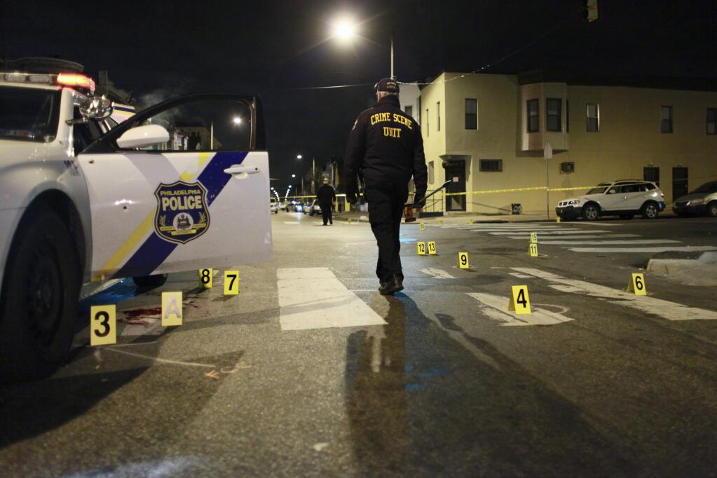 (File photo) A deadly shooting Friday, Sept. 16 in Philadelphia was the second to involve an ambush on a Philadelphia police officer this year. In this file photo, an investigator walks through the scene of a shooting Jan. 8, 2016. A Philadelphia police officer was shot multiple times by a man who ambushed him as he sat in his marked police cruiser, authorities said. (AP Photo/Joseph Kaczmarek)