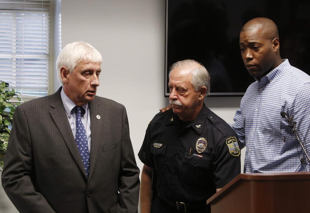 Virginia Beach Mayor Bobby Dyer, left, looks on as City Councilman Aaron Rouse, right, comforts Chief of Police James Cervera following a press conference, Friday, May 31, 2019 in Virginia Beach, Va. A longtime city employee opened fire at a municipal building in Virginia Beach on Friday, killing 11 people before police shot and killed him, authorities said. Six other people were wounded in the shooting, including a police officer whose bulletproof vest saved his life, said Virginia Beach Police Chief James Cervera. (Kaitlin McKeown/The Virginian-Pilot via AP)