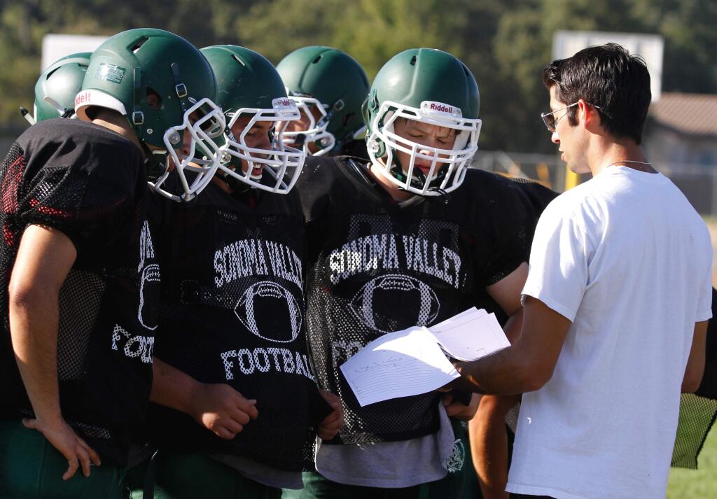 Bill Hoban/Index-TribuneDragon offensive coordinator Max Pond goes over some plays during practice Tuesday. The Dragons open their season tonight when they entertain Fremont at Arnold Field.