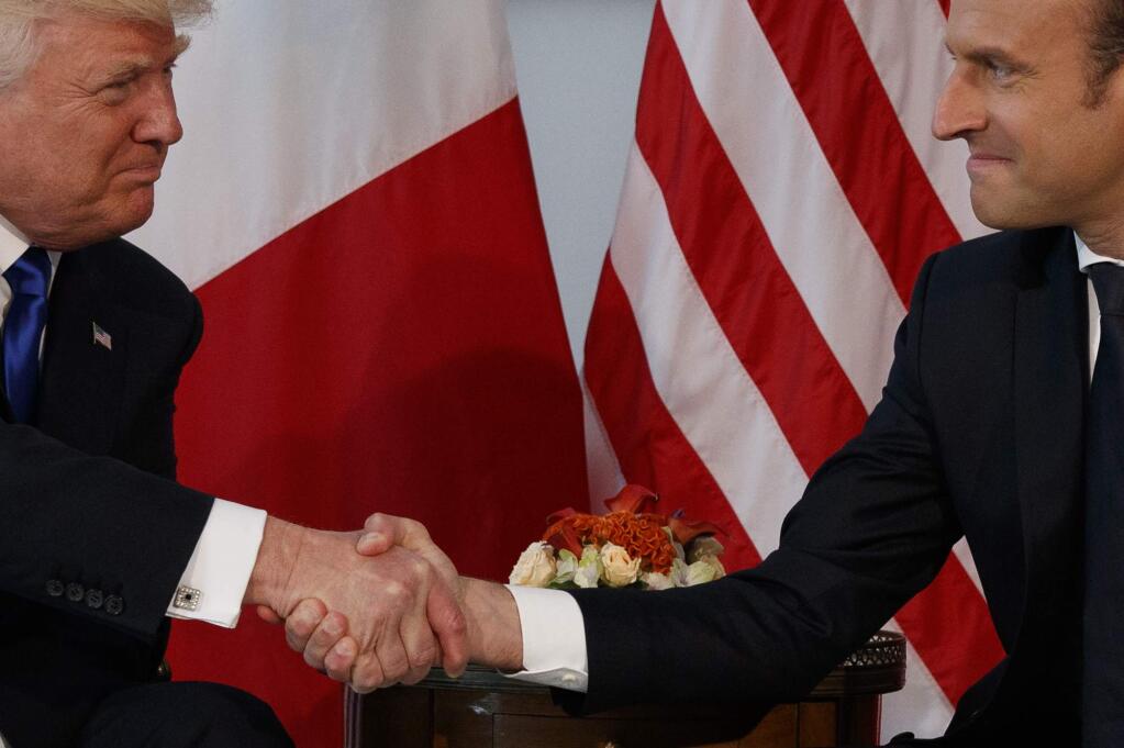 FILE - In this May 25, 2017 file photo, President Donald Trump shakes hands with French President Emmanuel Macron during a meeting at the U.S. Embassy in Brussels. Trump hasn't done a lot of public speaking during his big trip abroad. But the president's body language and that of those around him has spoken volumes. (AP Photo/Evan Vucci, File)