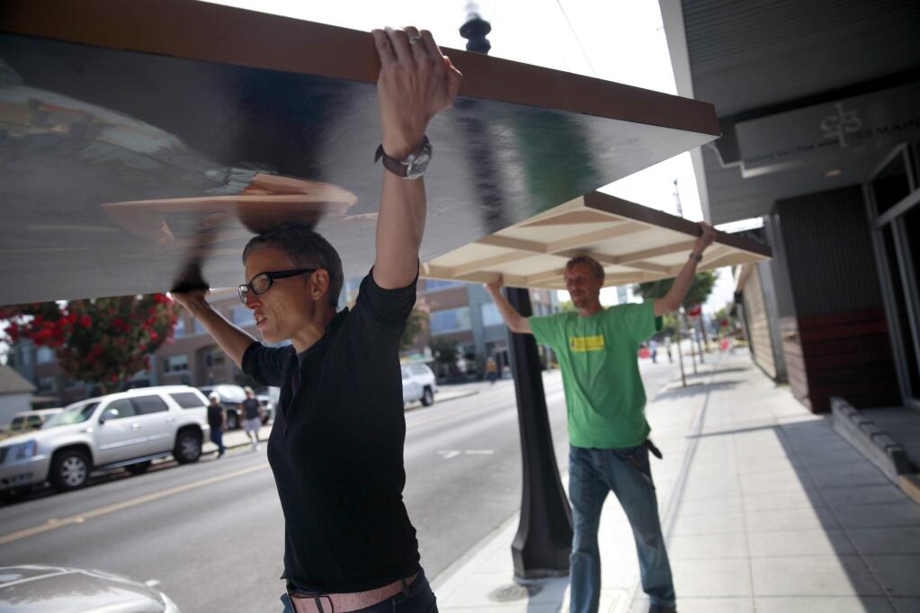 Vintner's Collective owner Kim Erasmy and employee Erick Smith, remove artwork from the damaged Pfeiffer Building following Sunday's earthquake on Monday, August 25, 2014 in Napa, California. (BETH SCHLANKER/ The Press Democrat)