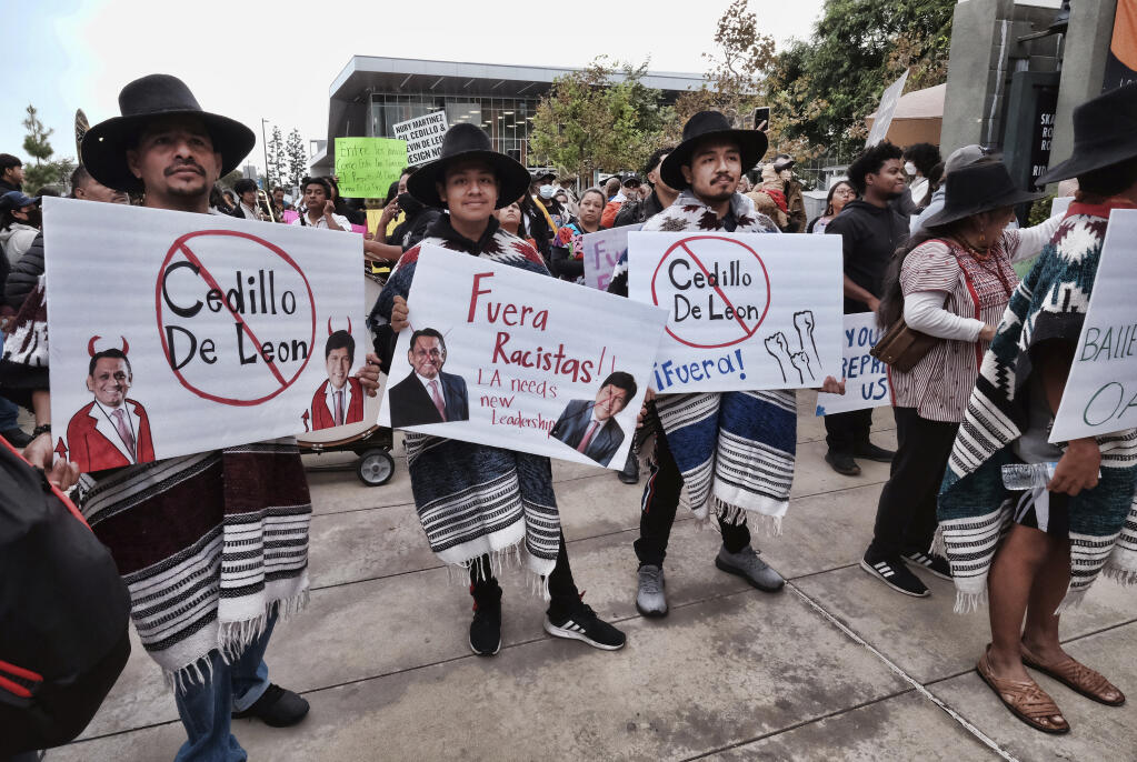 FILE - Members of Comunidades Indígenas en Liderazgo (CIELO) and leaders from Indigenous communities across California hold signs during a demonstration in Los Angeles, demanding the resignations of L.A. City Councilmen Kevin de León and Gil Cedillo for their participation in a leaked discussion that included racial slurs on Oct. 15, 2022. Embattled Los Angeles councilman Kevin de León attended his first city council meeting Friday, Dec. 9, 2022 in nearly two months since a scandal broke over racist remarks by elected officials. Since the scandal, De León has apologized but said he has no plans to resign. (AP Photo/Richard Vogel, File)