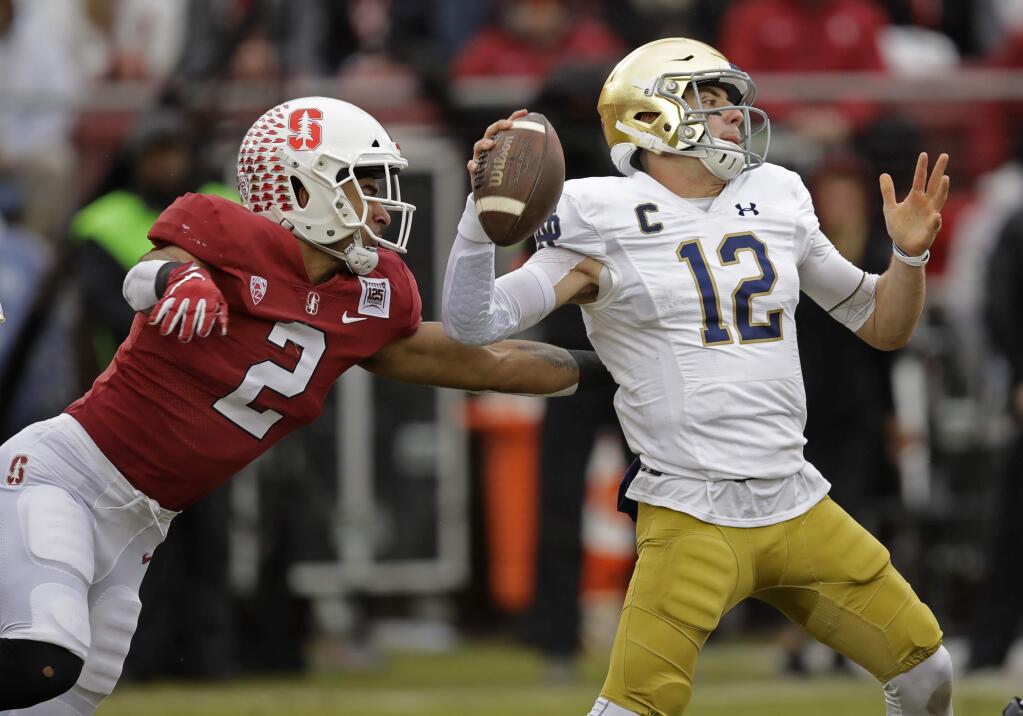 Stanford's Curtis Robinson, left, pressures Notre Dame quarterback Ian Book in the first half Saturday, Nov. 30, 2019, in Stanford. (AP Photo/Ben Margot)
