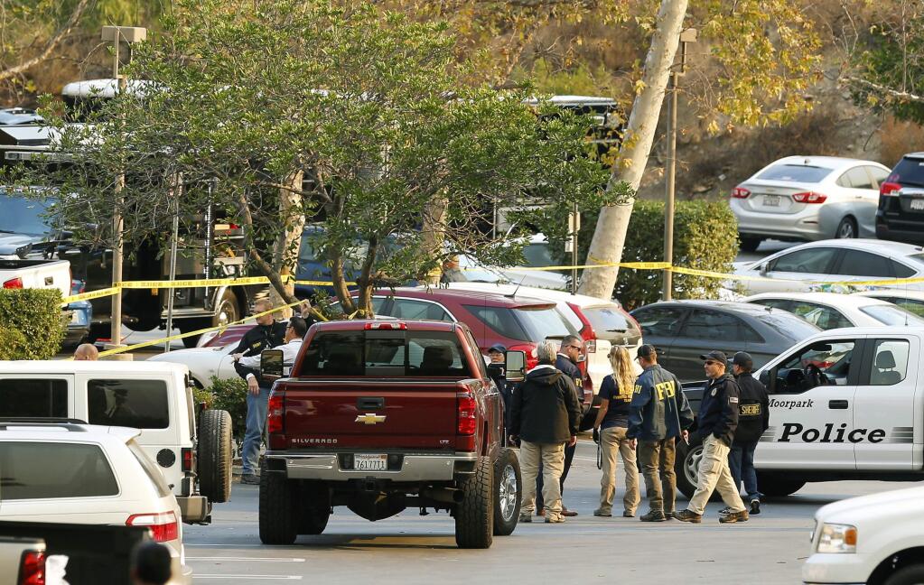 FBI investigators join law enforcement as they work near the scene of Wednesday's shooting in Thousand Oaks, Calif., Friday, Nov. 9, 2018. Investigators continue to work to figure out why an ex-Marine opened fire Wednesday evening inside a country music bar, killing multiple people. (AP Photo/Damian Dovarganes)