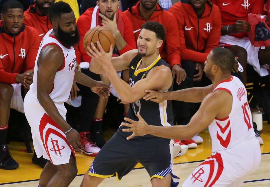 Golden State Warriors guard Klay Thompson is double-teamed by Houston Rockets guard James Harden, left, and guard Eric Gordon during Game 4 of the Western Conference Finals in Oakland on Tuesday, May 22, 2018. The Warriors lost to the Rockets 95-92. (Christopher Chung / The Press Democrat)