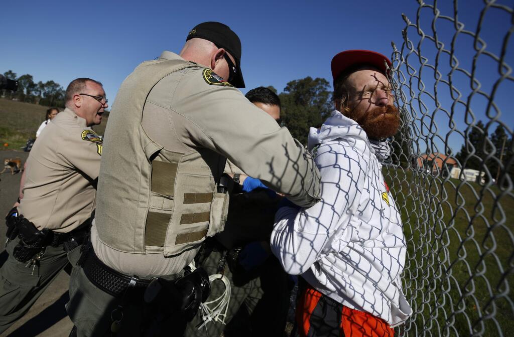 Sonoma County sheriff's deputies restrain a homeless man after an altercation at a homeless encampment along an unused portion of Bane Avenue just south of West Robles Avenue in Santa Rosa on Monday, Feb. 10, 2020. (BETH SCHLANKER/ PD)