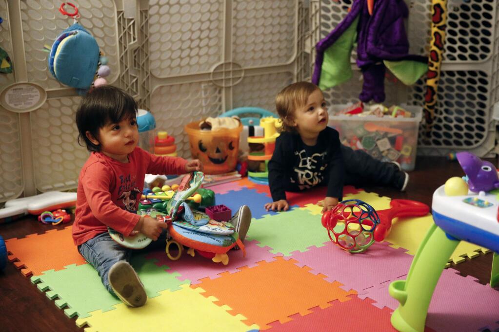 FILE - In this Jan. 23, 2018 file photo, sixteen-month-old Ethan Dvash-Banks, left, and his twin brother, Aiden, play in the living room of their apartment in Los Angeles. A federal judge in California has ruled that the twin son of gay couple Andrew and Elad Dvash-Banks has been an American citizen since birth, handing a defeat to the U.S. government, which had only granted the status to his brother. District Judge John Walter said Thursday, Feb. 21, 2019, that the State Department was wrong to deny citizenship to 2-year-old Ethan Dvash-Banks. (AP Photo/Jae C. Hong, File)