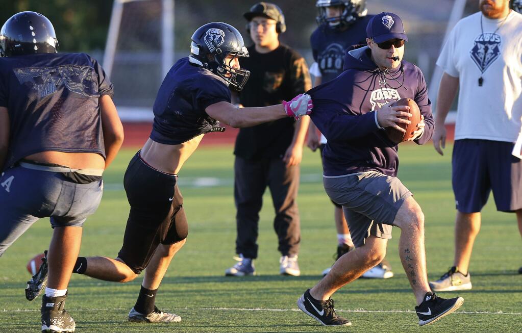 Then-Elsie Allen coach Derek Hester runs a play with his team during practice in Santa Rosa in November 2017. (Christopher Chung / The Press Democrat)