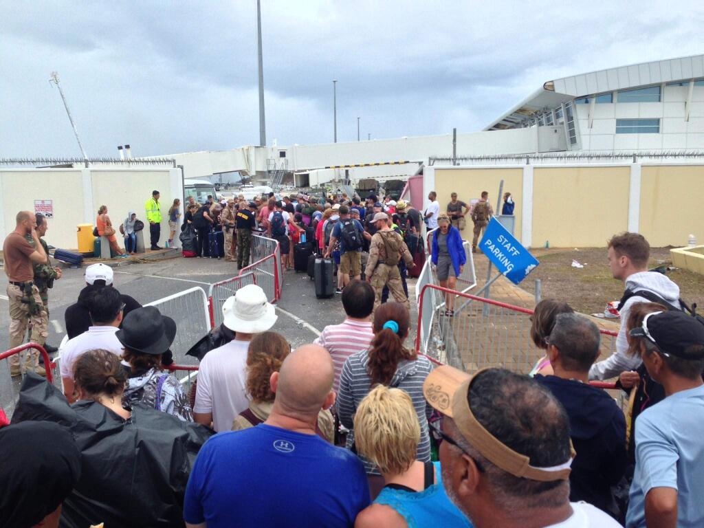 People line up at the airport to leave St. Maarten on Saturday, Sept. 9, 2017, after Hurricane Harvey strikes the island. (Matt Popovich/Twitter)