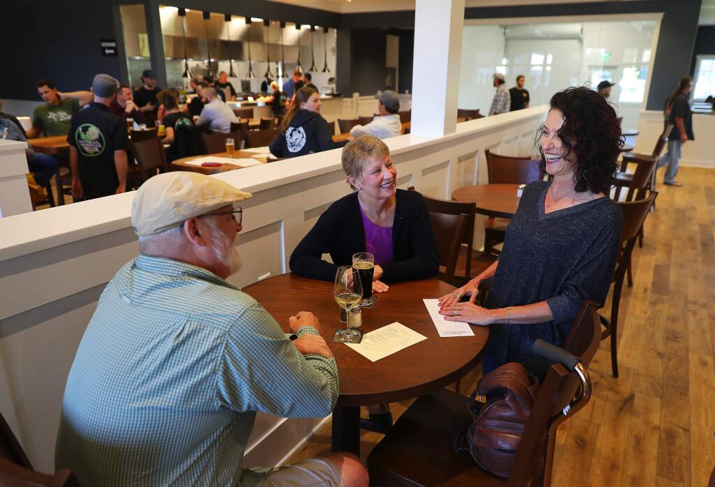 Russian River Brewing Company co-owner Natalie Cilurzo, right, visits with Wendy Petersen and Gerald King at the new Russian River Brewing Company location in Windsor on Tuesday, October 9, 2018. (Christopher Chung/ The Press Democrat)