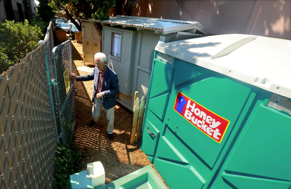 Property owner and former Santa Rosa mayor Dave Berto placed four tiny huts, a port potty and sink for the homeless outside the window of the office he has used for the past 50 years. (photo by John Burgess/The Press Democrat)