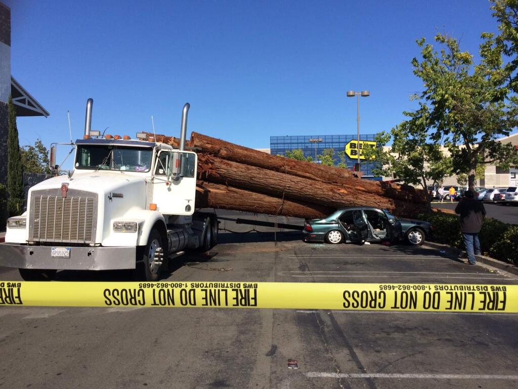 This logging truck spilled its load onto a small car in the Costco parking lot Wednesday in Santa Rosa, but the woman and children inside the vehicle weren't seriously hurt. (Conner Jay / PD)
