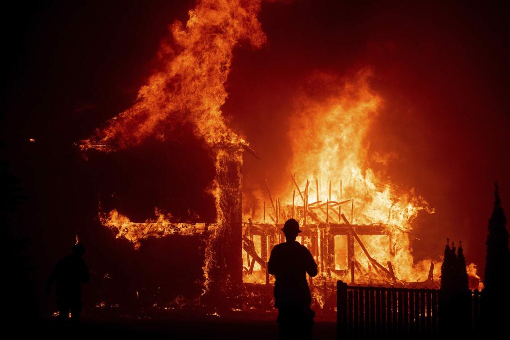FILE - In this Nov. 8, 2018 file photo a home burns as the Camp fire rages through Paradise, Calif. (AP Photo/Noah Berger, File)