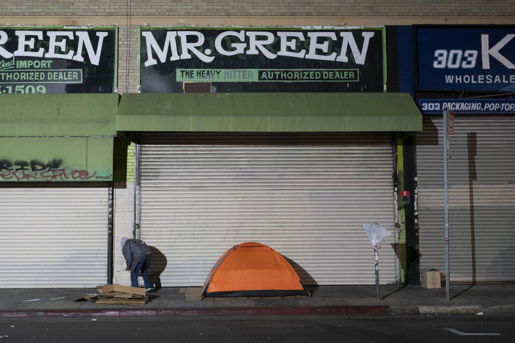 FILE - A homeless man stands next to his tent in Los Angeles, Wednesday, Dec. 14, 2022.  (AP Photo/Jae C. Hong, File)