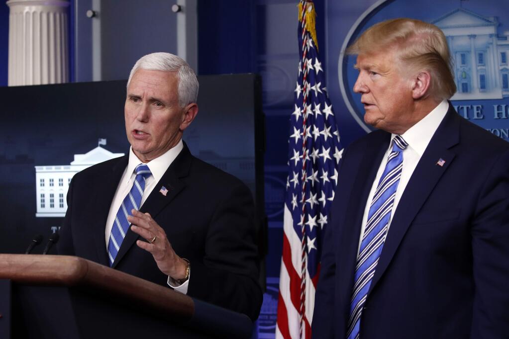 President Donald Trump listens as Vice President Mike Pence speaks about the coronavirus in the James Brady Briefing Room, Monday, March 23, 2020, in Washington. (AP Photo/Alex Brandon)