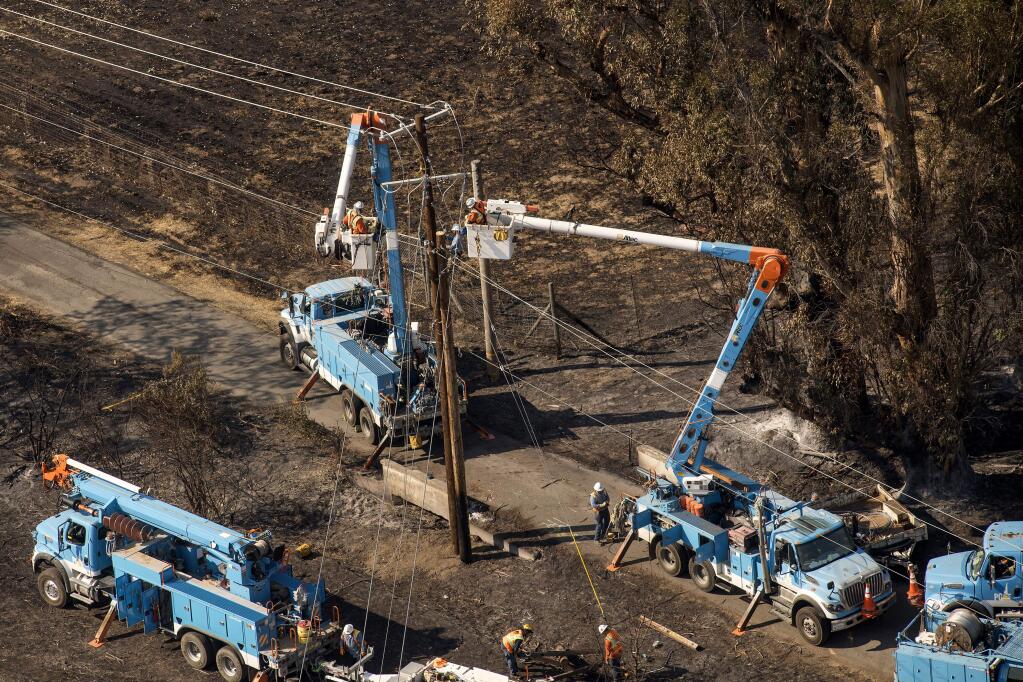 PG&E employees work to fix downed power lines in Santa Rosa on Oct. 12 (DAVID PAUL MORRIS / Bloomberg)